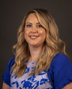 Dr. Melanie Langille has long blond hair and wears and blue and white floral top.